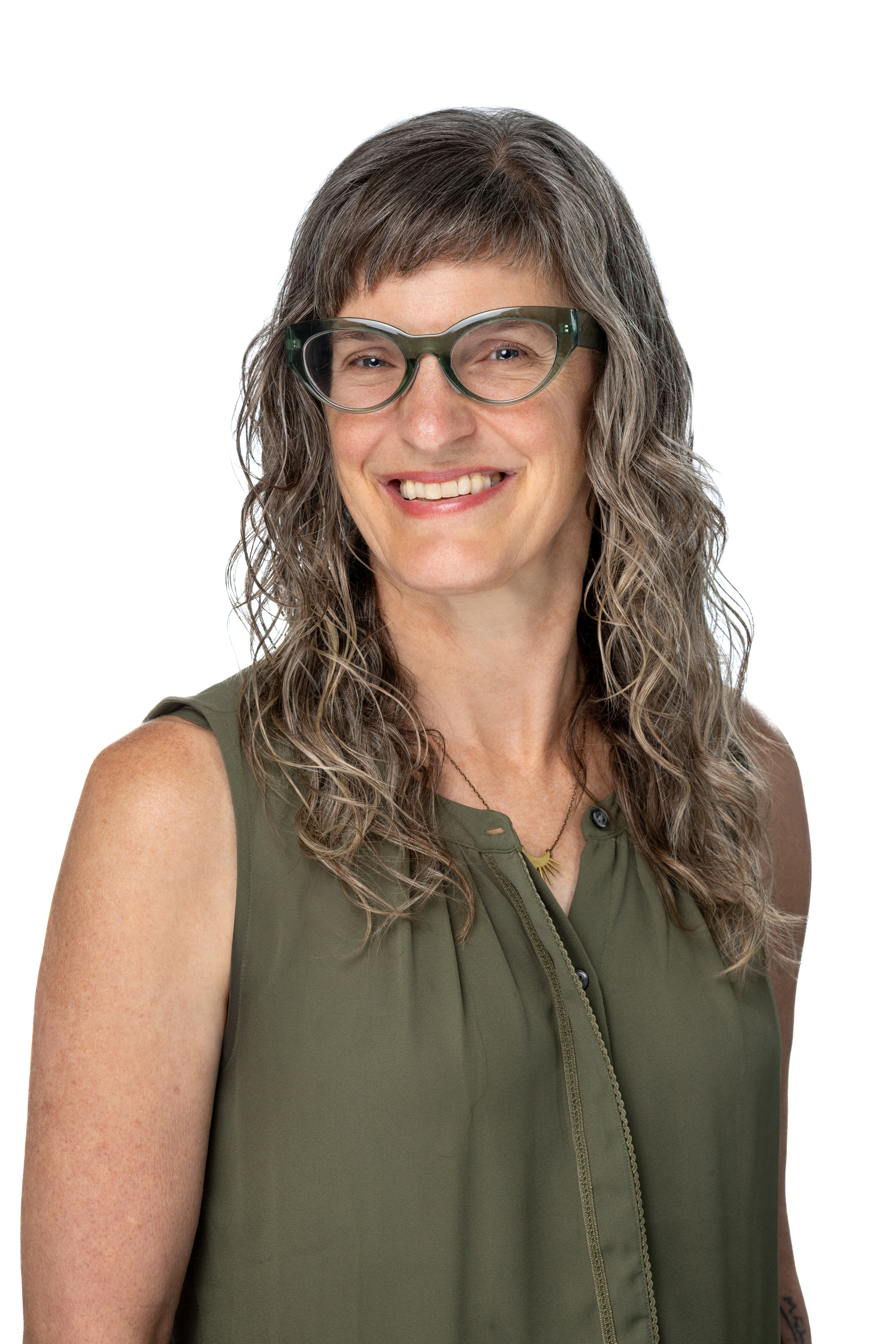 Kate Phillippo, PhD, LCSW, wearing green-framed glasses and a sleeveless olive blouse, smiling against a light gray background.